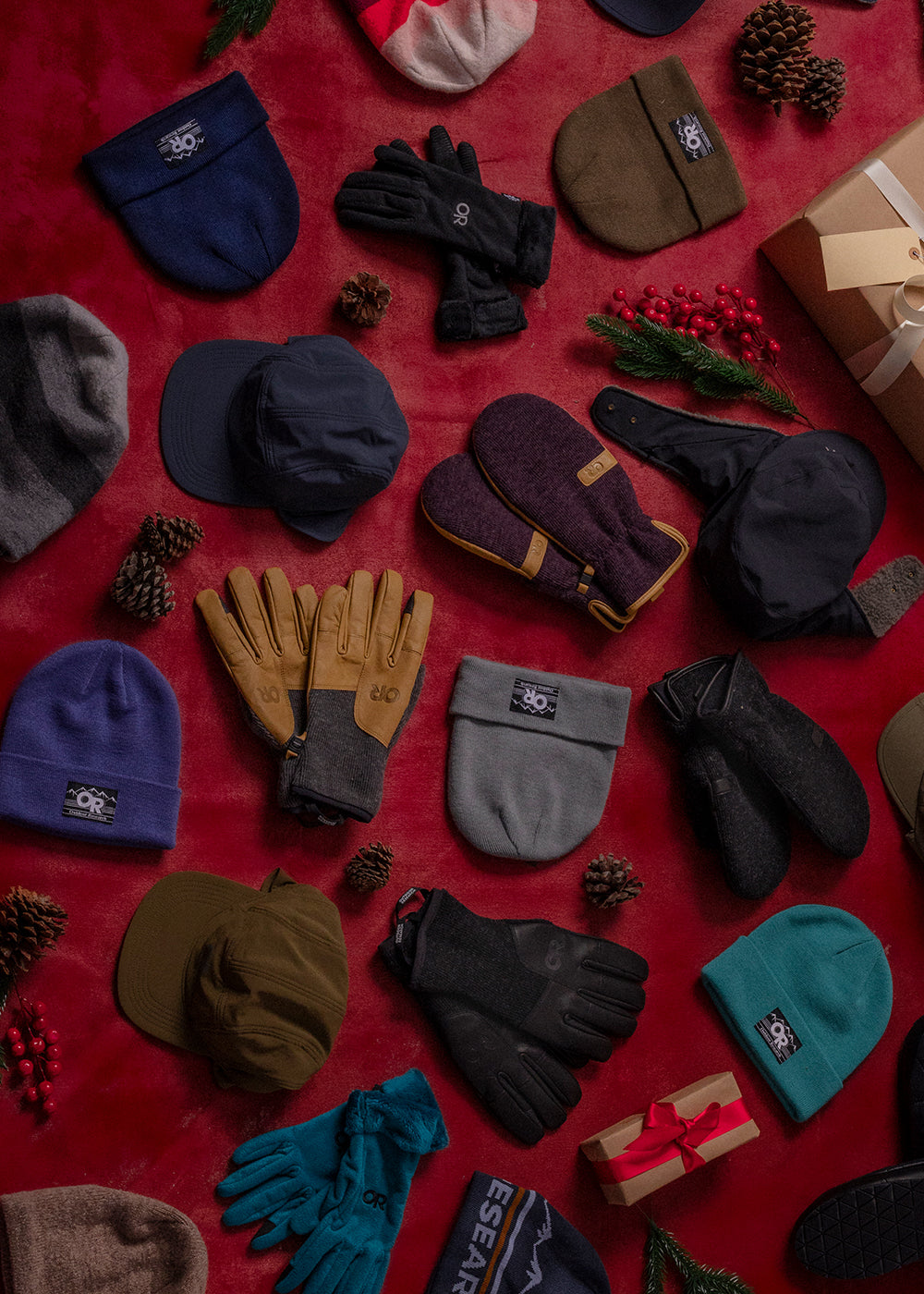 Collection of winter accessories including hats, gloves, and scarves on a red background.