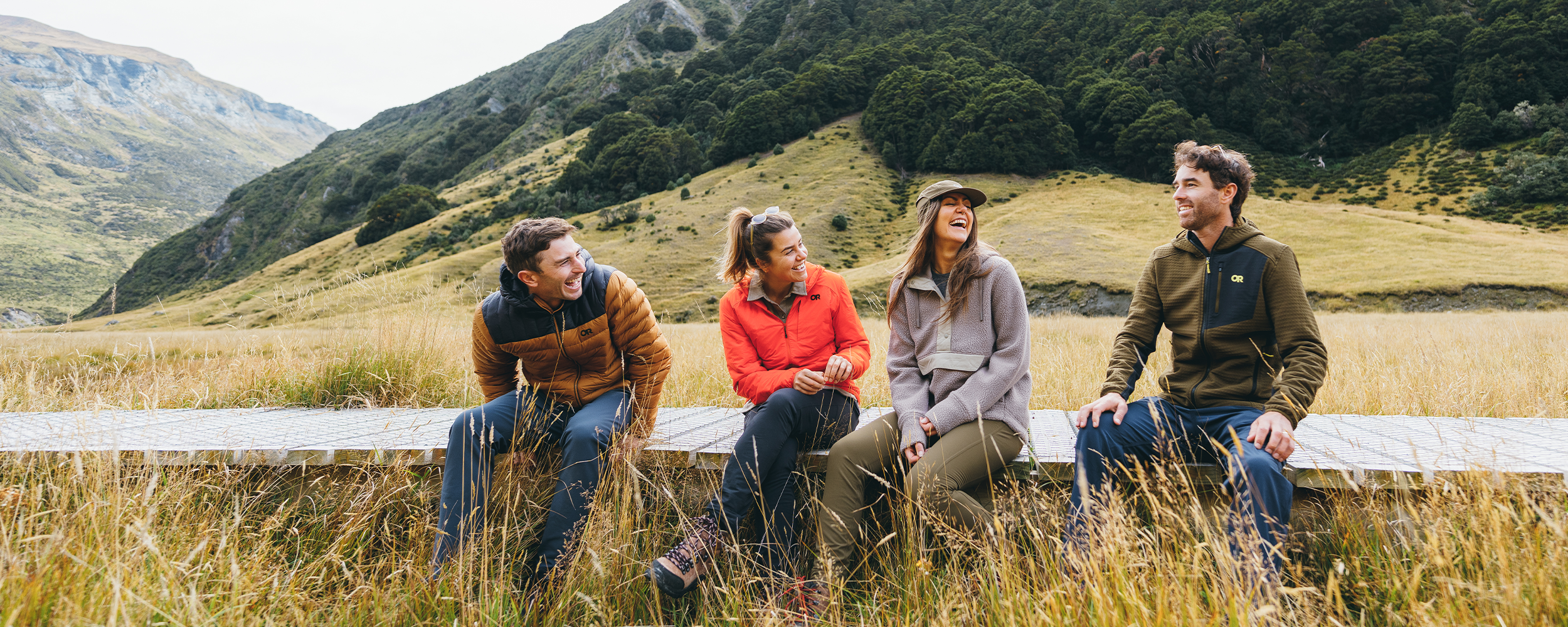 A group of friends climb to the viewpoint on a hike while wearing Outdoor Research outerwear and sportswear. 