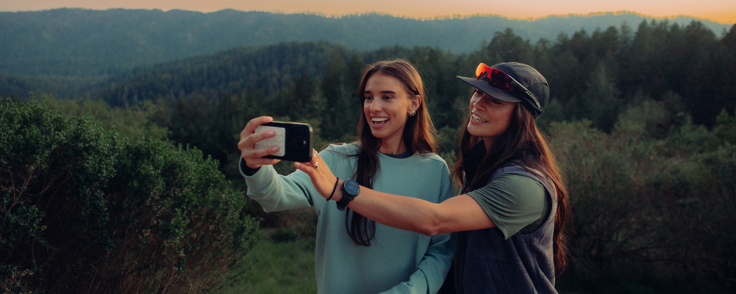 Woman wearing a white t shirt and the Outdoor Research Odyssey Multi Shorts in blue poses next to a canyon. 