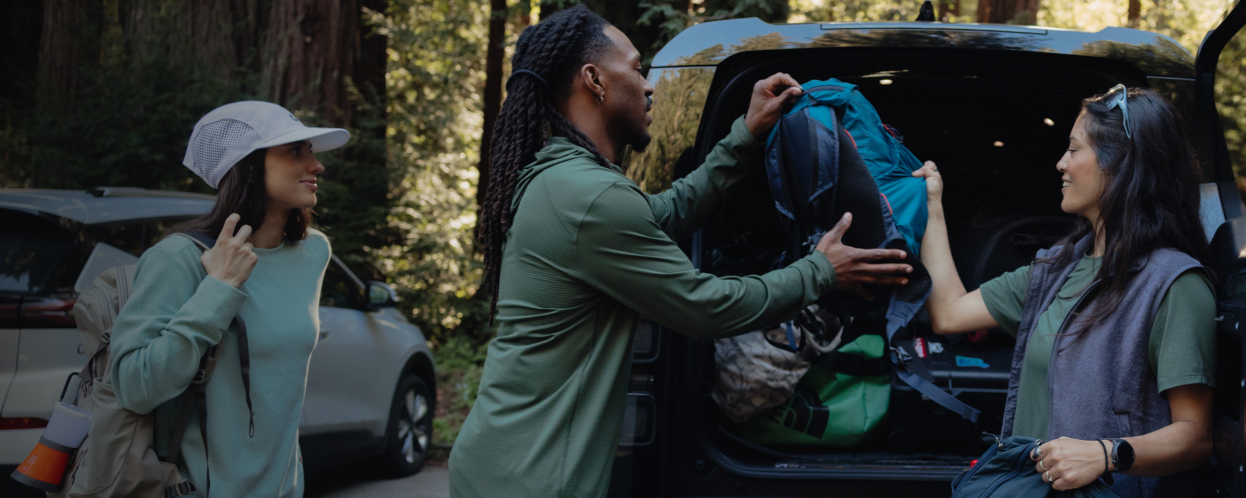 Male packing the car wearing Outdoor Research sportswear. 