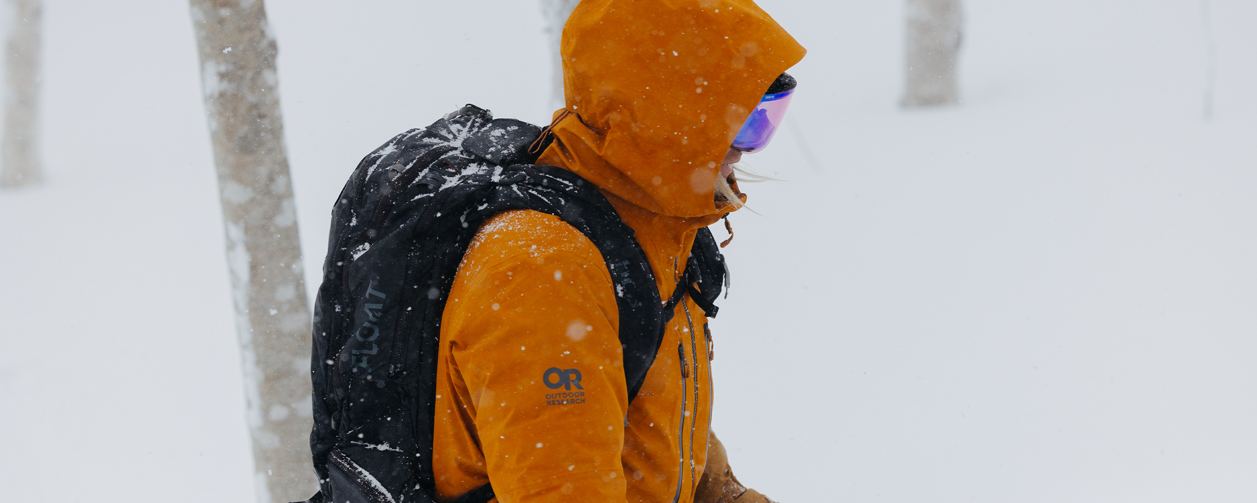 Male climbing snow mountain wearing Outdoor Research Men's Headwall Gore-Tex 3L Jacket Lingonberry. 