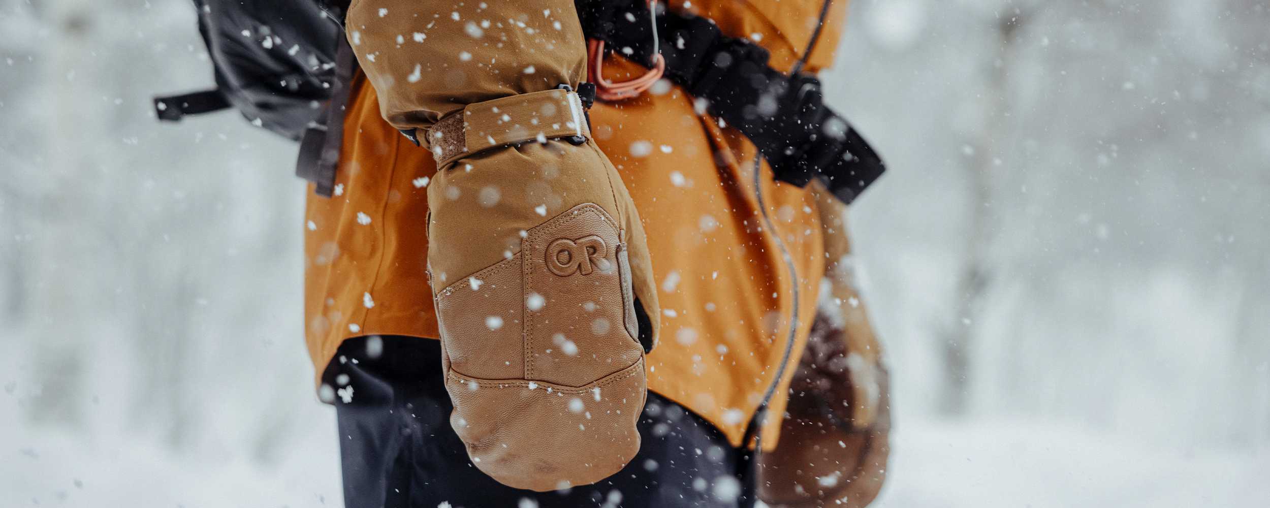 A skier holds their ski poles wearing the Outdoor Research Women's Revolution Undercuff GORE-TEX Gloves in Sable.