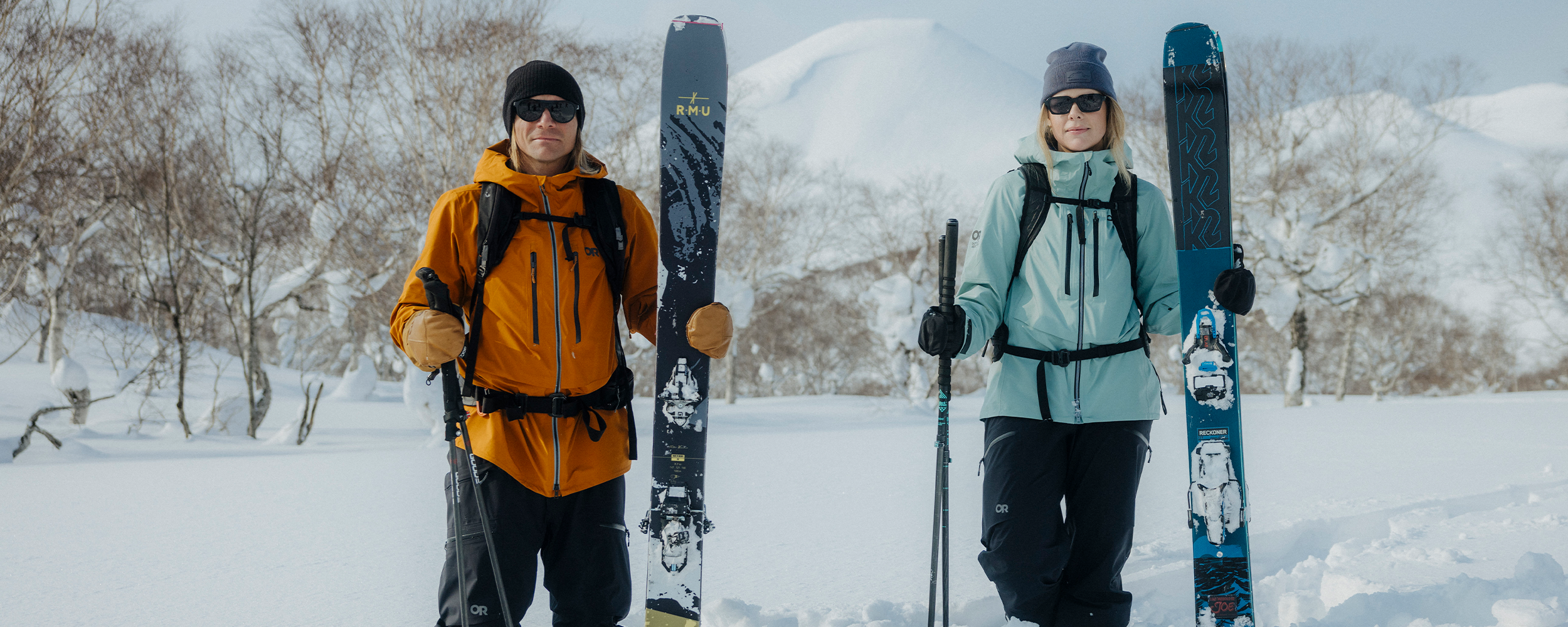 Two friends traverse through the snow on skies wearing Outdoor Research Skytour AscentShell Jackets.