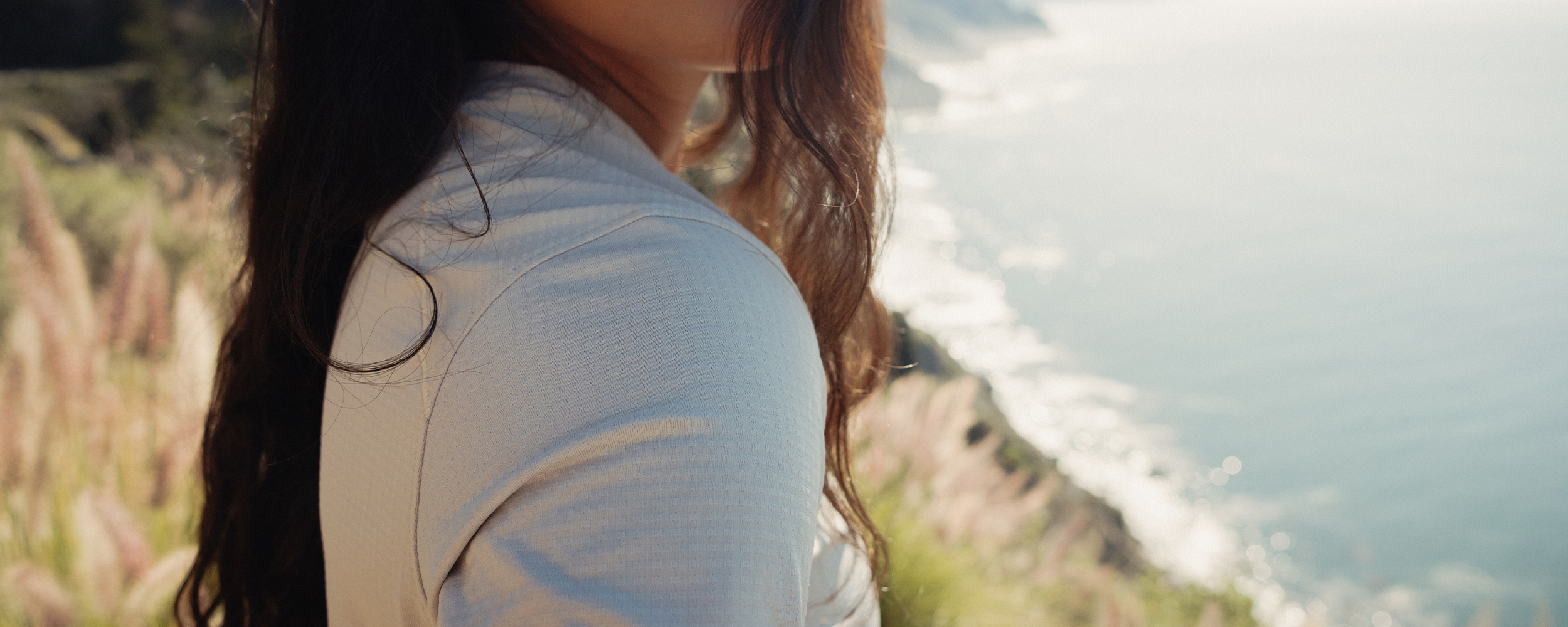 Woman climbing rock wearing Outdoor Research sportswear. 