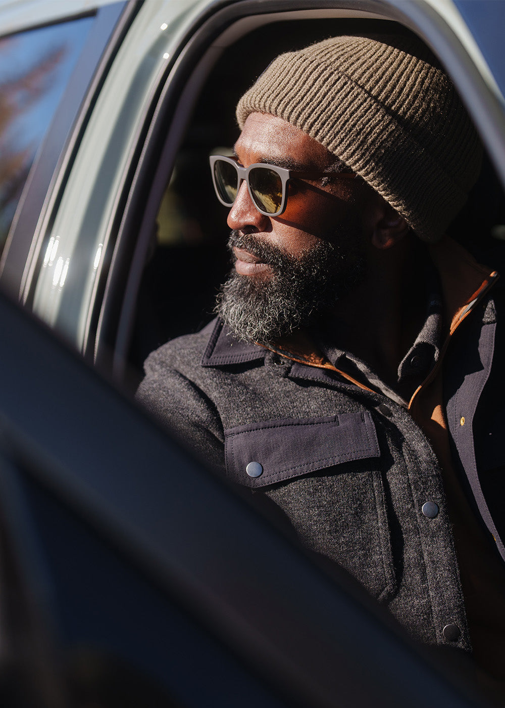 Male sitting in his car looking out wearing Outdoor Research Men's Ranger Shirt Jacket Black and Tokul Beanie.
