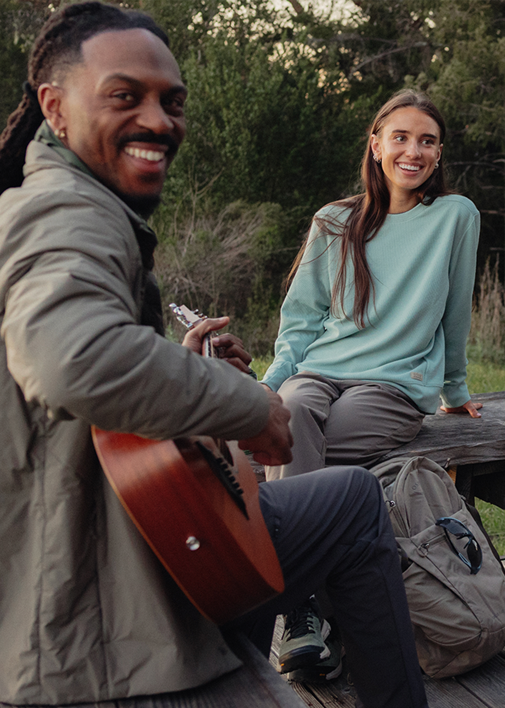 A group of friends sitting outside together wearing Outdoor Research sportswear and outerwear. 