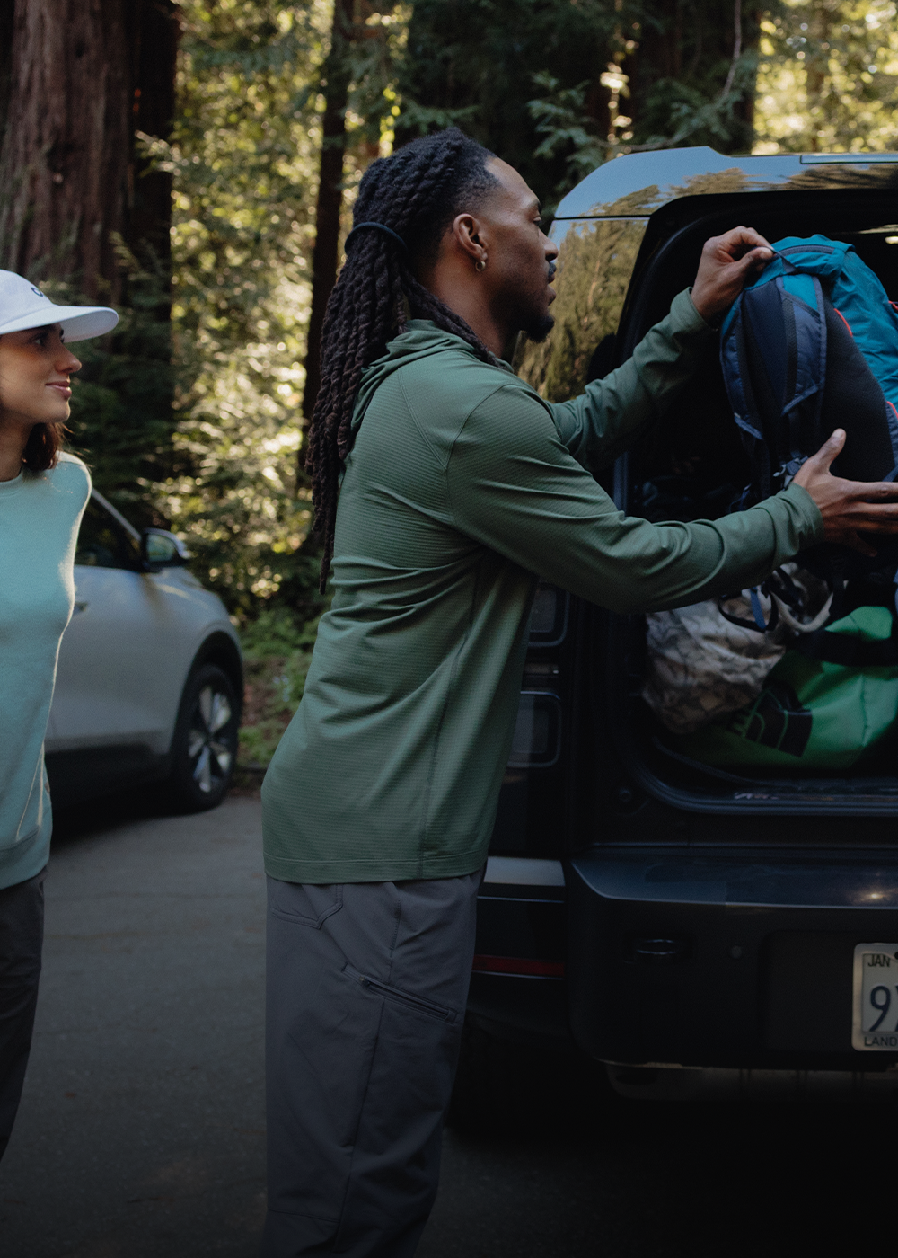 Male packing the car wearing Outdoor Research sportswear. 