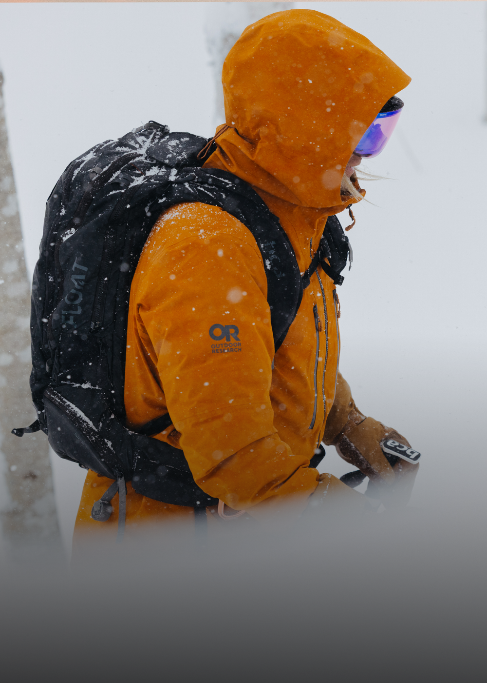 Male climbing snow mountain wearing Outdoor Research Men's Headwall Gore-Tex 3L Jacket Lingonberry. 