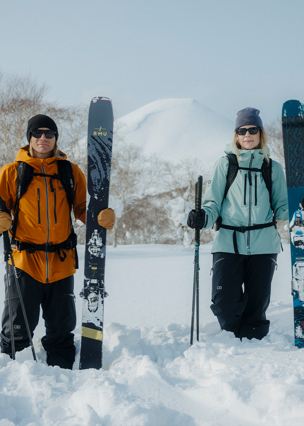 Two friends traverse through the snow on skies wearing Outdoor Research Skytour AscentShell Jackets.