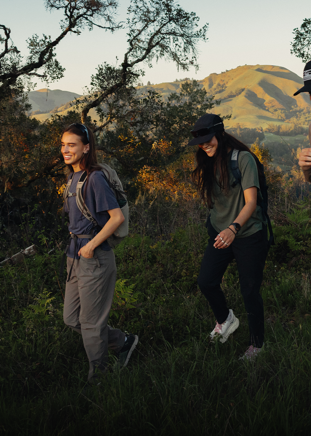 4 friends walking along a trail in the mountains wearing Outdoor Research Women's Crescent Fleece Full Zip Hoodie Sable, Women's Trail Mix XT Fleece Cowl Oyster, and Men's Trail Mix XT Fleece Half Zip Atlantic. 