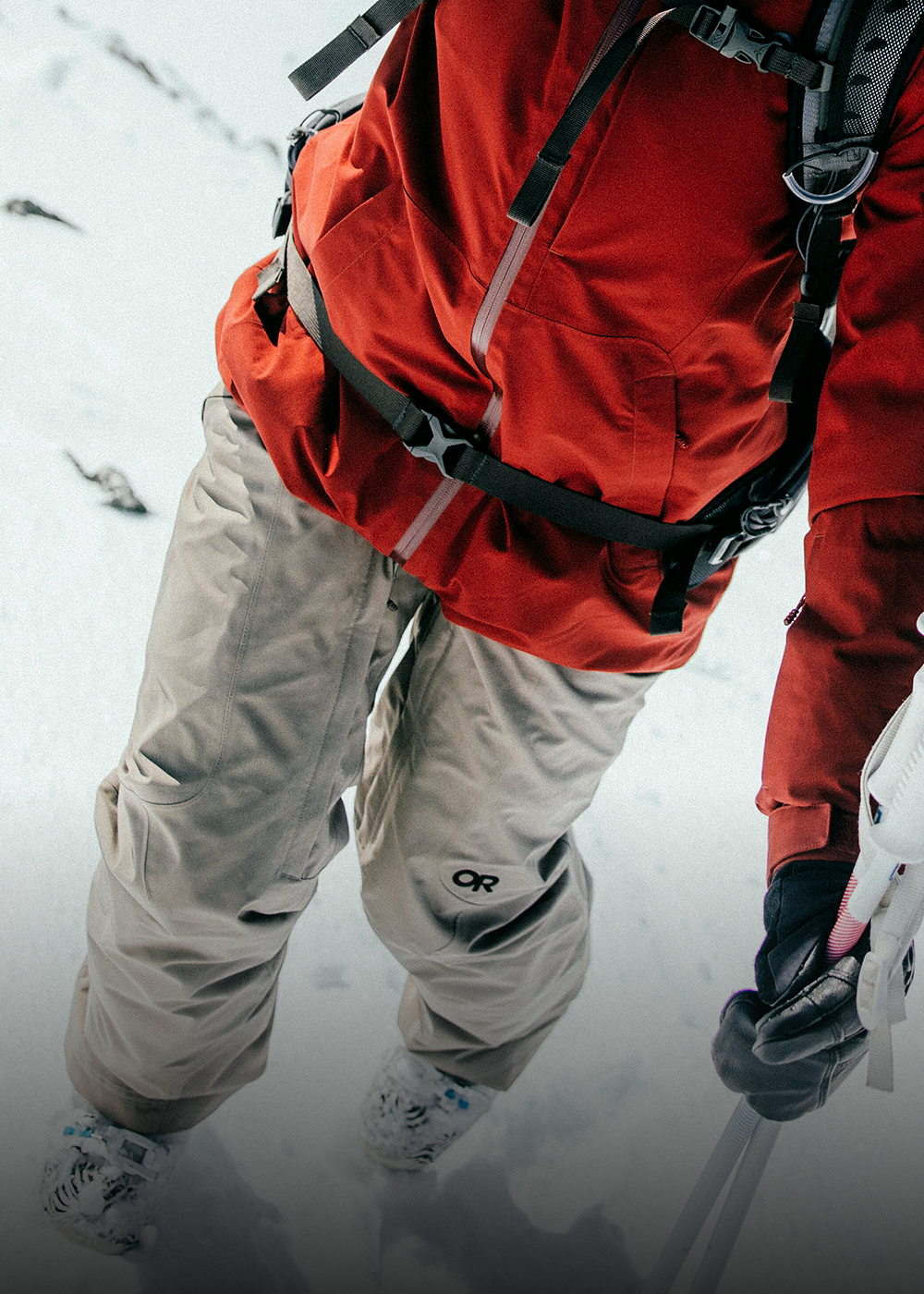 Female skiing with trees in the background wearing Outdoor Research Women's Powderverse Jacket Oyster/Sable and Women's Powderverse Pants Sable. 