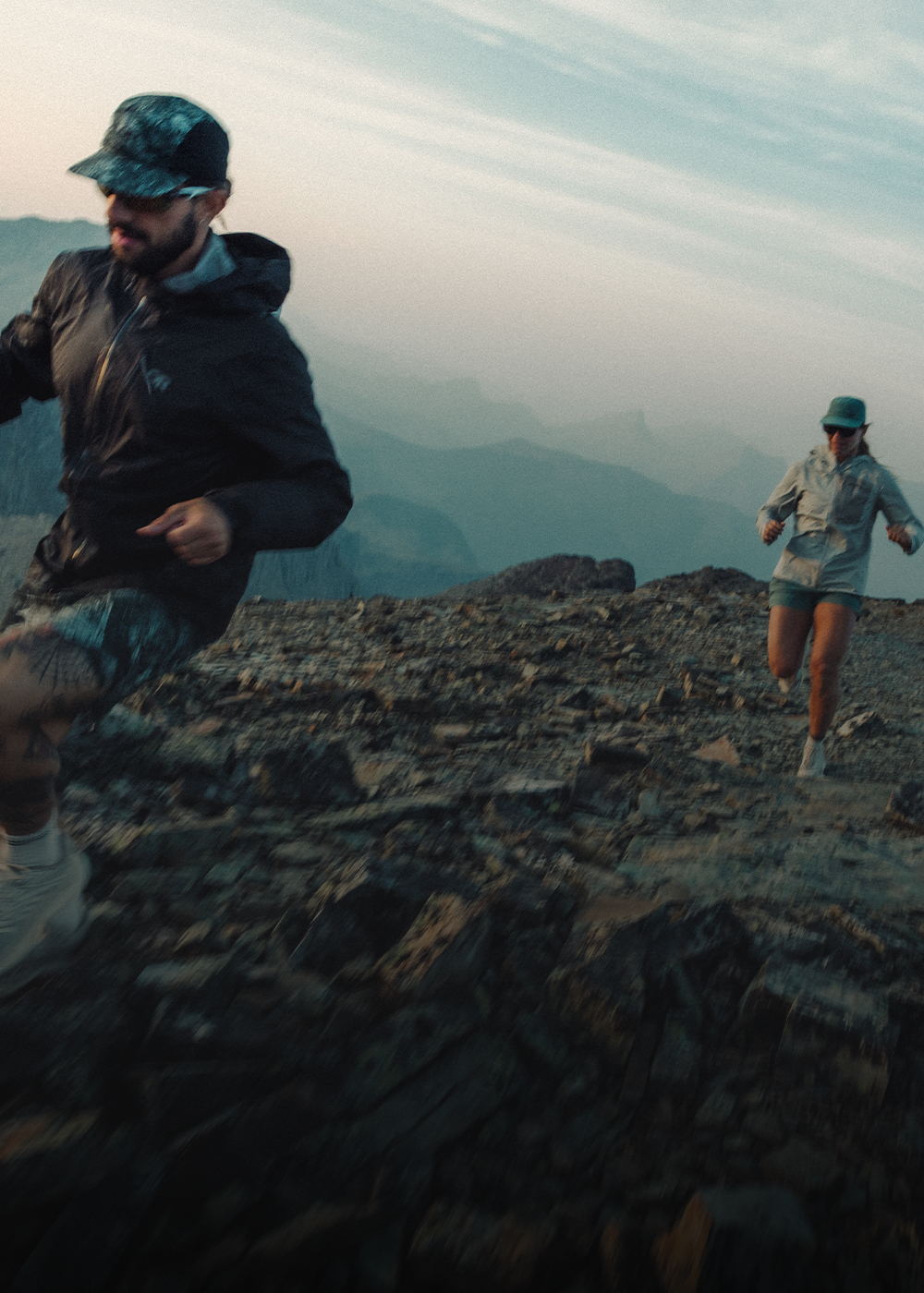 A female looking away and leaning against the deck with a cup of coffee wearing Outdoor Research Women's Grayland Fleece Pullover Hoodie Summit.