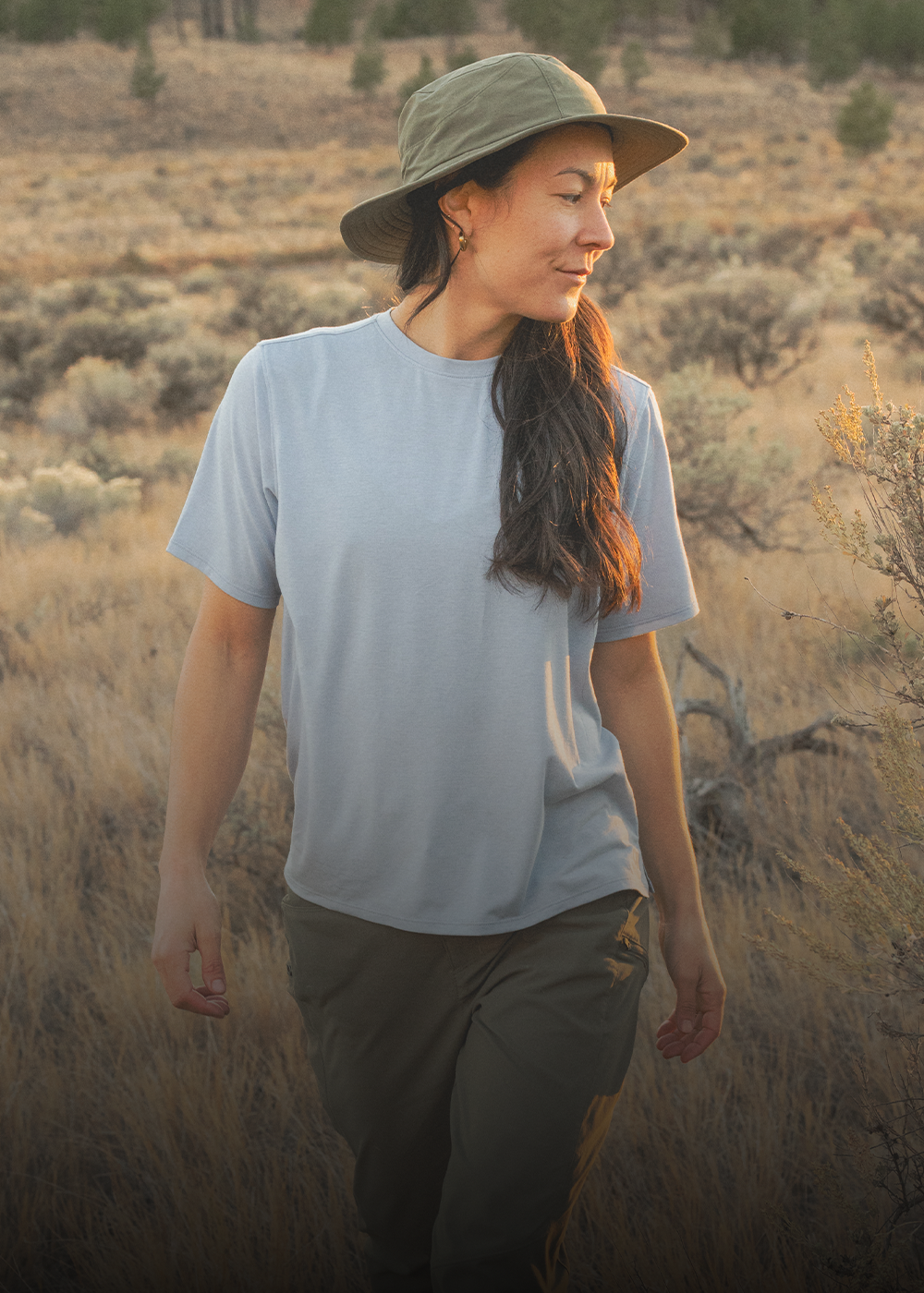 Female sitting in the sun wearing Outdoor Research Stratoburst Rain Hat Sedona. 